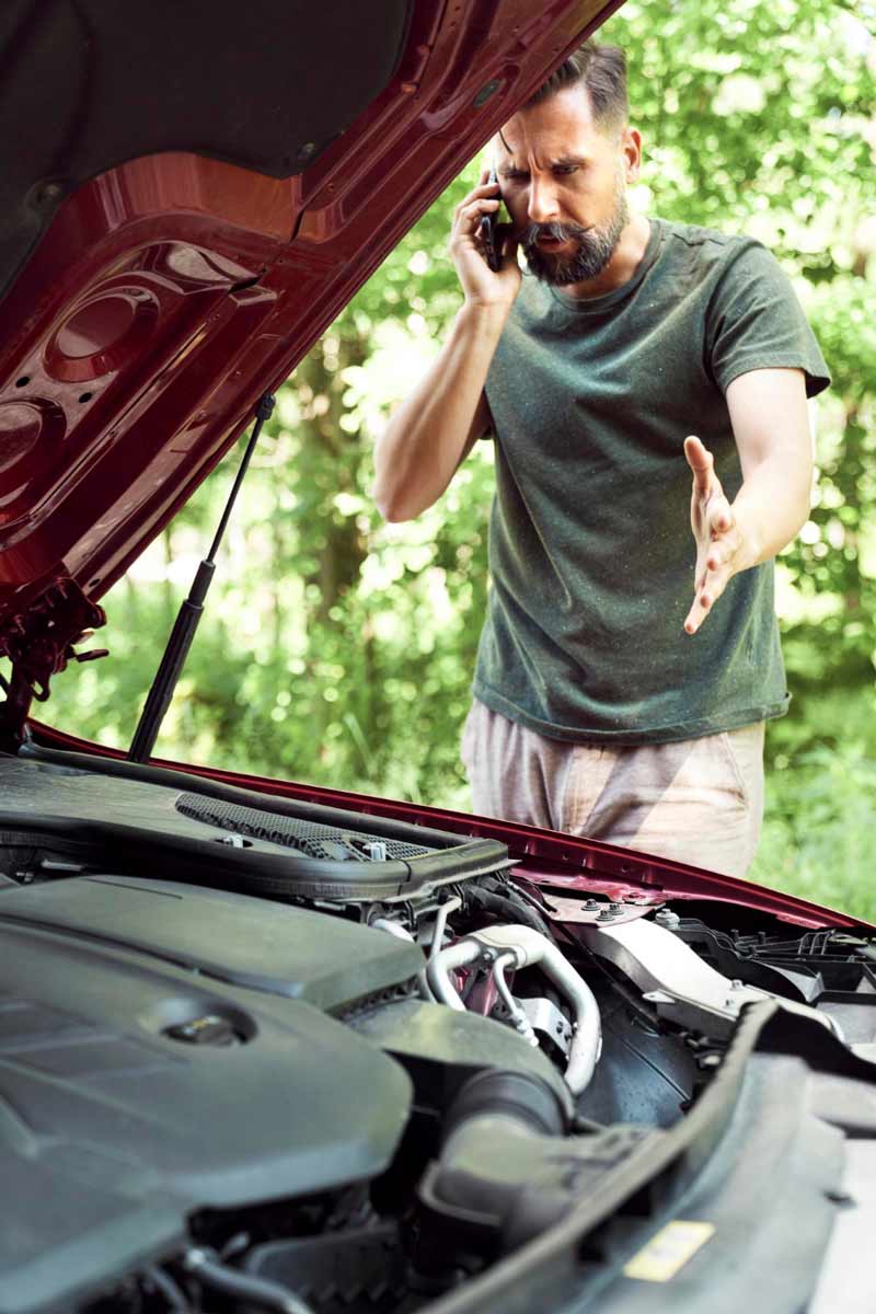 Junger Mann prüft Getriebeschaden bei Schrottauto Ankauf Neumünster